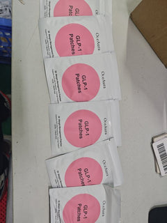 Multiple boxes of GLP-1 patches on a white surface